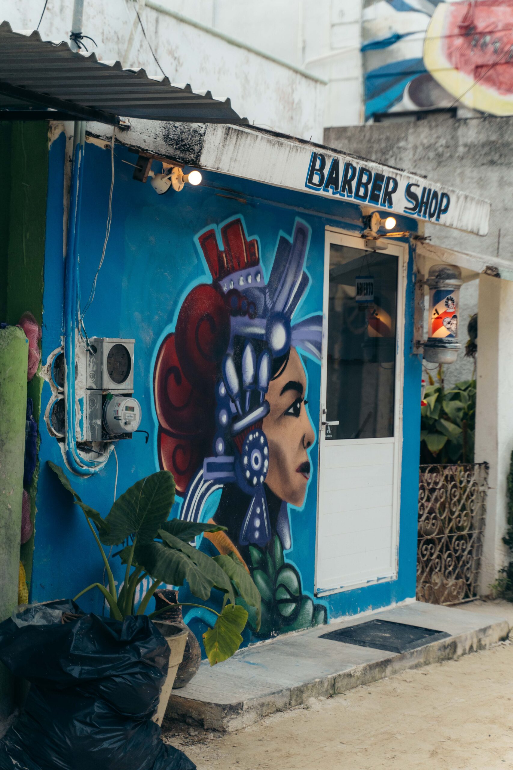 Street art featuring traditional barber shop elements on Calle Carito in Holbox Island.
