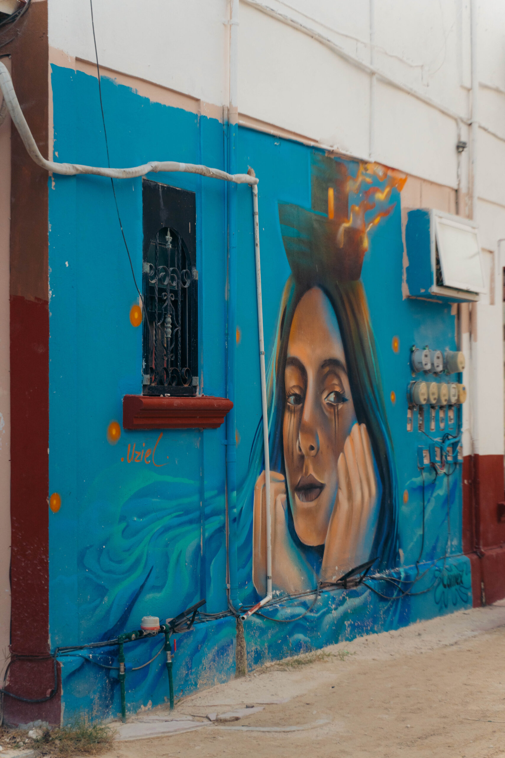Mural of a woman wearing an ornate headdress, highlighting cultural artistry on Calle Carito in Holbox Island
